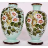 A pair of 20th century hand painted glass vases with florals painted to sides.