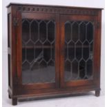 A jacobean style oak bookcase display cabinet having leaded glass with shelved interior.