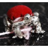 A 20th century white metal (stamped 925 for silver ) frog shaped pin cushion having red baised pin