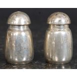 Two Sterling silver 20th century salt/pepper condiments having mushroom style tops and body.