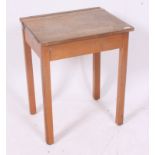 A vintage 1950's mid 20th century school desk with hinged top raised on squared supports.