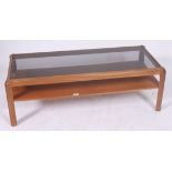 A 1970's smoked glass and teak rectangular coffee table having inset glass top raised on end