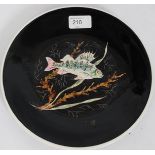 A pottery plate, painted with a Carp against a black ground,