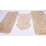 A group of vintage 20th century Sheepskin hide rugs some with labels attached to the verso.