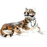 A ceramic figurine of a recumbant Siberian tiger being stamped to the underside USSR.