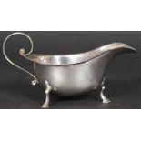 A Mappin & Webb silver hallmarked sauce boat being raised on hoof feet.