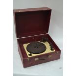 A cased vintage 1940's 1950's portable record player in claret containing a Gerrard record deck,