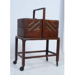 A vintage 1950's retro metamorphic sewing box raised on stand.