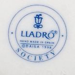 A Lladro Society Porcelain plaque with dove atop blue Lladro Society stamp to  base. Measures 11.
