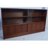 A vintage 1970's low teak library bookcase cabinet having open shelves with sliding door cupboard