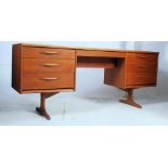 A 1950's large teak wood Danish style writing table desk - dressing chest being raised on angled