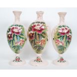 A set of three Victorian glass painted vases, each decorated with floral panels,