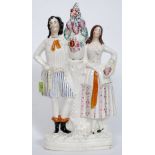 A Victorian large Staffordshire flatback figurine of a gentleman and lady either side of a vase of