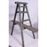 A vintage 20th century painted industrial wooden folding large trestle complete with plank having