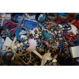 A large box of assorted vintage and contemporary costume jewellery to include brooches, bangles,