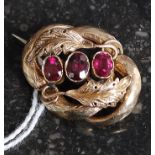 A 9ct gold and amethyst ladies brooch. The three central stones with leaf surrounds.