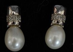 A pair of ladies decorative styled white gold cultured pearl and diamond earrings.
