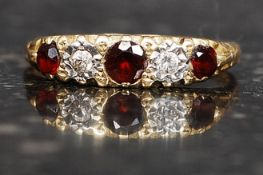 An 18ct gold ring with 3 garnets and 2 4pt diamonds in a gypsy setting. Weight 3.1g. Size R.