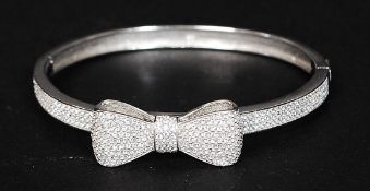 A ladies decorative silver and cz stoneinset bangle with bow decoration to centre. Total weight 17.