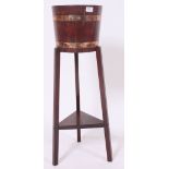 An early 20th century coopered oak barrel plant stand - jardiniere on tripod base with under tier.