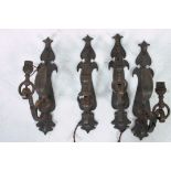 A set of 4 gilded metal wall lights having decorative sconces of scrolled form.