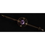 A 9ct gold bar brooch with central amethyst stone set within twin circles. Marked 9ct. Weight 4g.