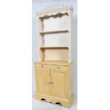 A 20th century pine painted shabby chic dresser having upright gallery plate rack over cupboard