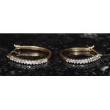 A pair of ladies 9ct gold and diamond earrings being channel set.