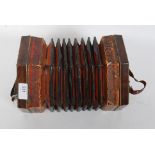 A vintage wooden squeeze box accordion instrument with central bellows and push buttons to both