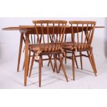 An Ercol blond beech and elm wood refectory dining table together with a set of 4 Ercol low