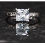 A silver 925 single CZ stone being cushion cut on claw mount with round cz  cut stones to shoulders.