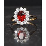 A 9ct hallmarked gold ring set with CZ and a central red gemstone. Weight 2.3g.