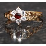 A 9ct gold hallmarked cluster ring set with CZ and central garnet within heart shaped shoulders.