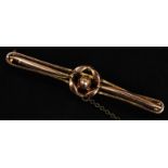 A 9ct gold bar brooch with central circular motif complete with safety chain. Weight 1.9g.