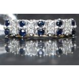 A 9ct gold, diamond and sapphire channel set ring. The central stones approx 1pnts each.