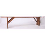 A 19th century French provincial pine refectory pig bench having a planked top with angled supports
