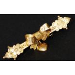 A 9ct gold bar brooch with bow and floral motif with heart pendant. Marked H&W 9ct. Total weight 1.