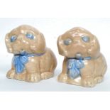 A pair of 1930's Sylvac style ceramic ornaments of puppy dogs, each with blue bows.