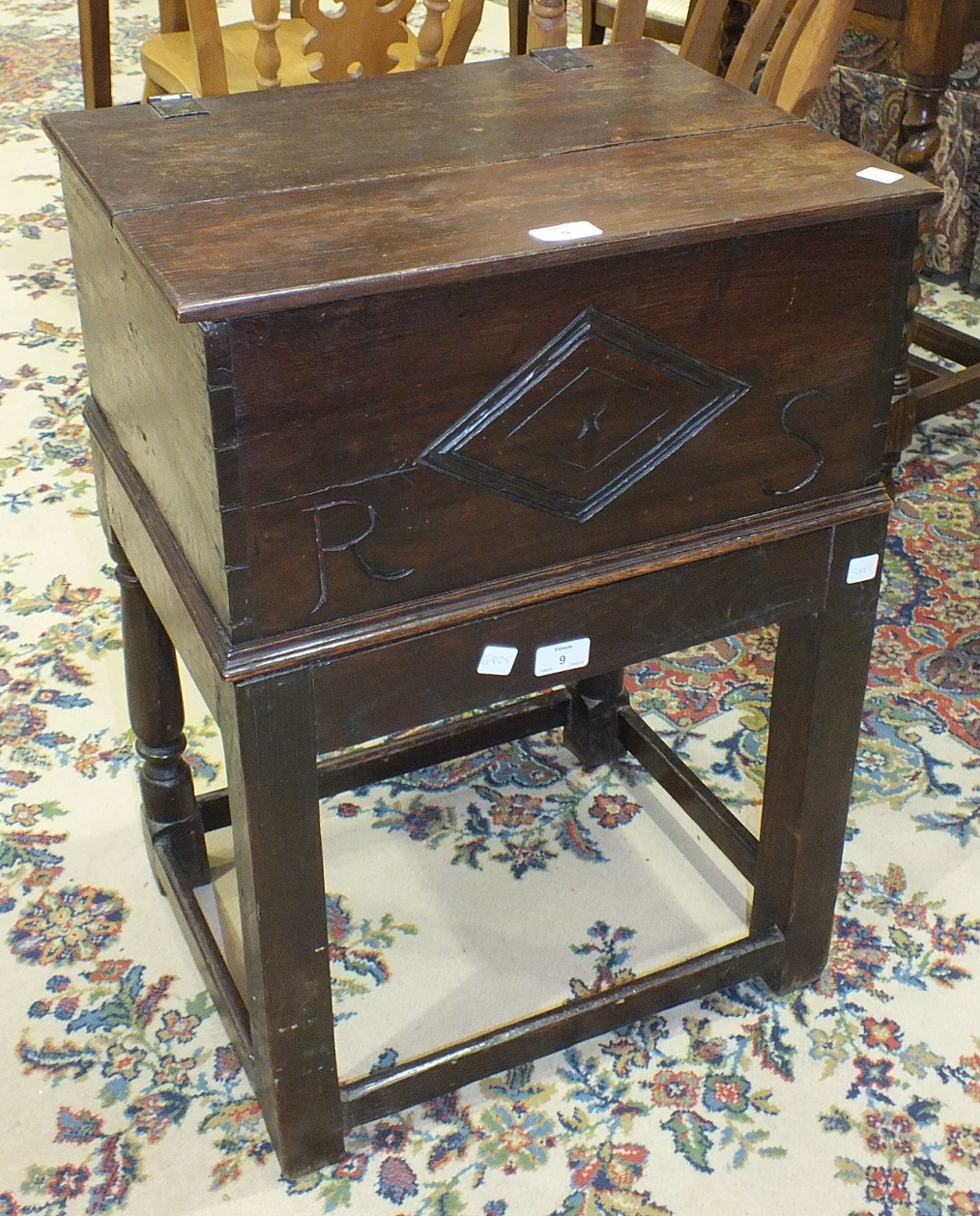 An oak bible box with hinged lid and carved front panel, 48cm wide, 23cm high, on stand.