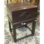 An oak bible box with hinged lid and carved front panel, 48cm wide, 23cm high, on stand.