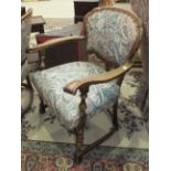 A pair of Continental stained wood armchairs, the upholstered shaped back and seat on turned front