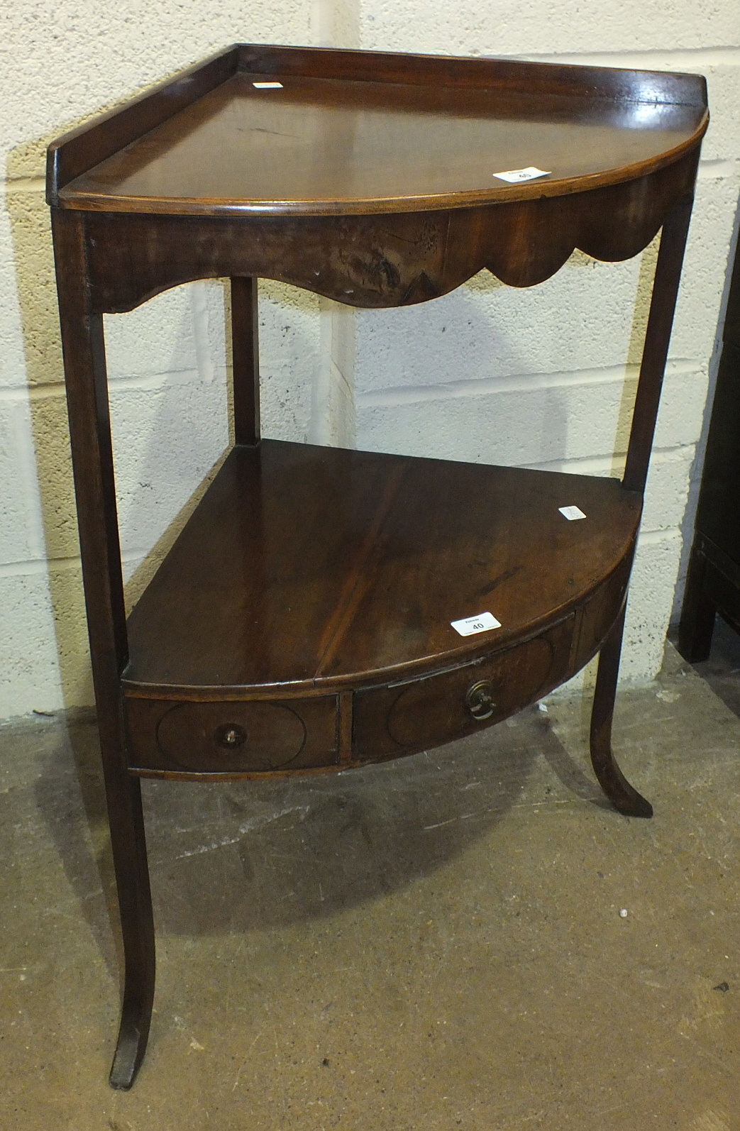 A 19th century mahogany bow-fronted two-tier corner wash stand, the lower tier with central drawer