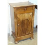 An early-20th century Continental walnut bedside cupboard, the rectangular top above a frieze drawer