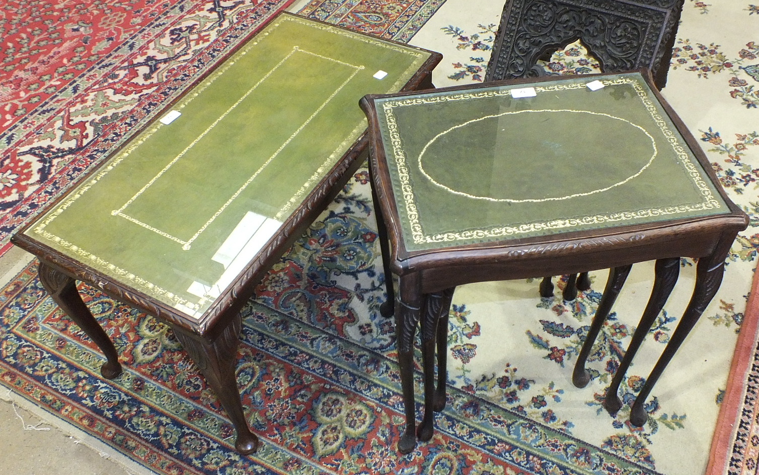 A nest of three modern stained wood tables, each with leather insets and plate glass tops, 50cm wide