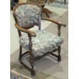 A pair of Continental stained wood armchairs, the upholstered shaped back and seat on turned front