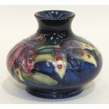 A William Moorcroft small compressed vase in the orchid pattern, 7cm high, painted mark and paper