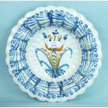 An 18th century Delft fluted dish decorated with a large tulip, 30cm diameter.