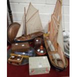 A modern wooden model of a fishing sailing boat, 63cm wide, 61cm high, another similar smaller model