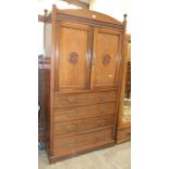 A late-19th century walnut linen press and drawers in the Aesthetic taste, the half-turned cornice