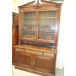 An Edwardian oak dresser, the shaped pediment above a pair of glazed doors, three frieze drawers and